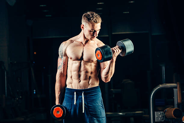 istock Athlete muscular bodybuilder training back with dumbbell  in the gym 487787982