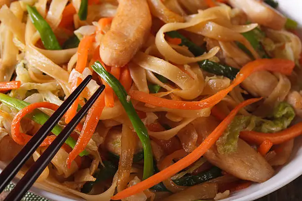 Photo of Delicious food: fried noodles with chicken and vegetables macro