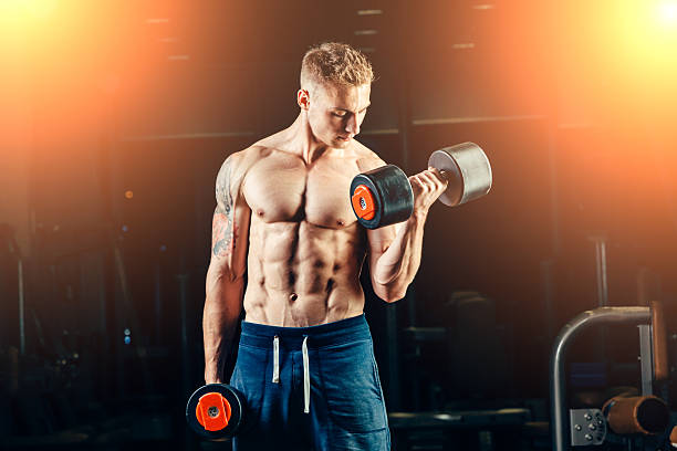 istock Athlete muscular bodybuilder training back with dumbbell  in the gym 487791472
