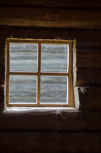 Bright square window inside the loghouse.