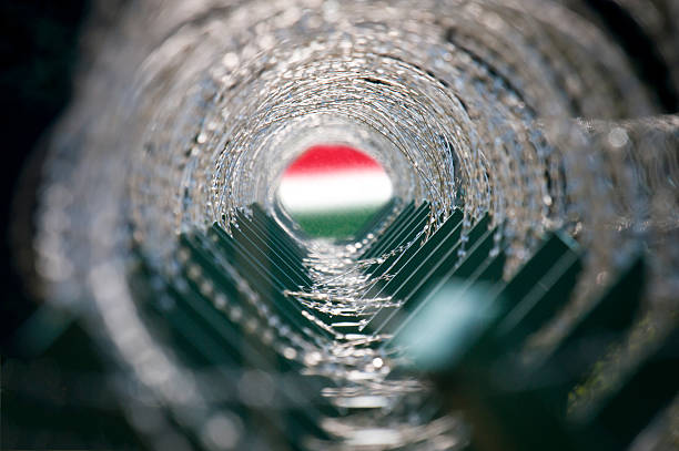 Concept image of a tunnel made of barbed wire and Hungarian flag at the end of the tunnel