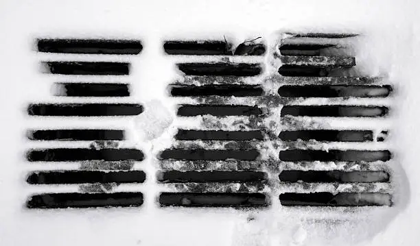 Photo of Storm drain covered by snow.