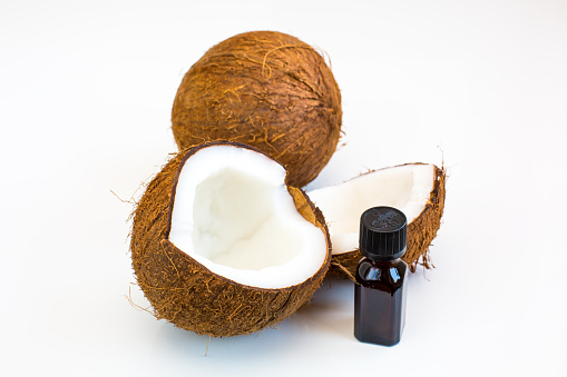 Still life with Half of Fresh coconut, bottle of coconut oil on the white background