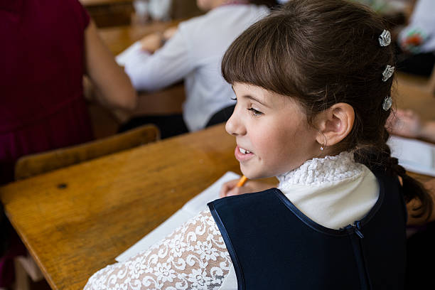 istock Girl sits at a school desk on the first day. 487797496