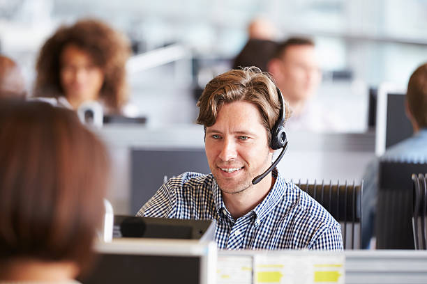 istock Young man working in call centre, surrounded by colleagues 487800316