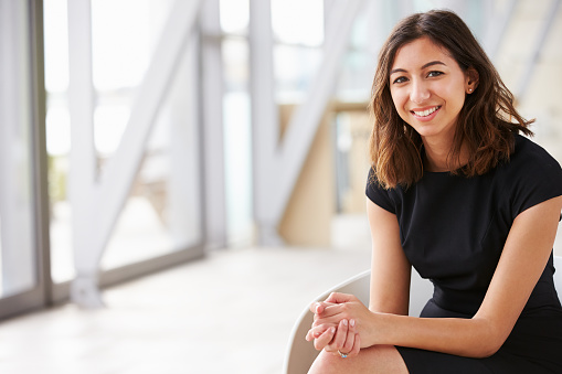 Portrait of young mixed race Asian businesswoman sitting