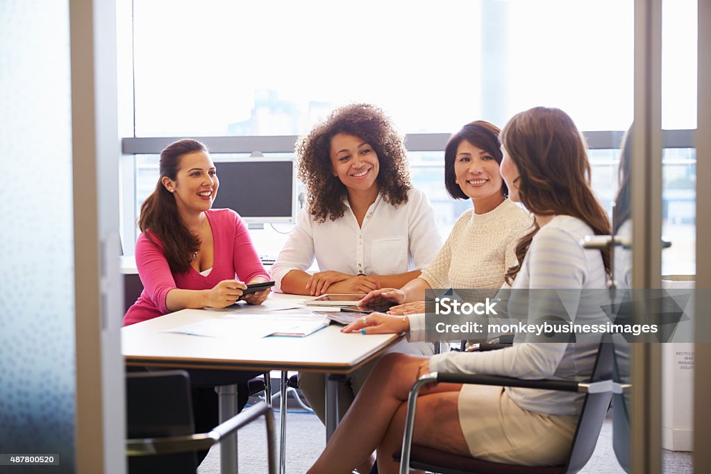 Casualmente vestidos colegas conversando em uma sala de reuniões - Foto de stock de Mulheres royalty-free