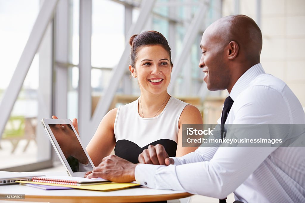 Two corporate business colleagues working together in office Face To Face Stock Photo