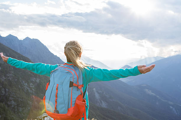 istock Mountaineer stands on mountain summit arms outstretched 487805122