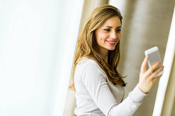 istock Beautiful brunette using a phone in a stylish house 487805424