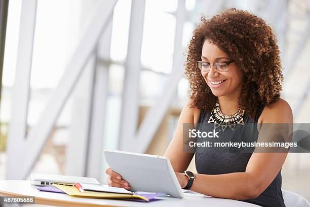 Foto de Jovem Mulher Afroamericana Com Tablet No Escritório Trabalhando e mais fotos de stock de Mesa digital