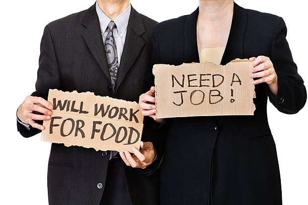 Subject: Unemployed office workers holding cardboard sign job hunting in a economic recession.