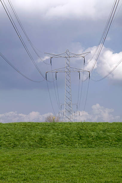 istock Power lines and pylons in a meadow with big clouds. 487807927