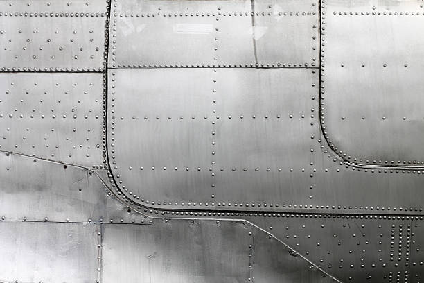 Aircraft siding with rivets Aluminum fuselage and rivets in old airplane. fuselage stock pictures, royalty-free photos & images