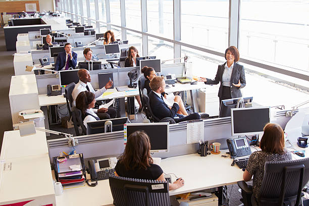 istock Asian female manager addressing workers in open plan office 487808590