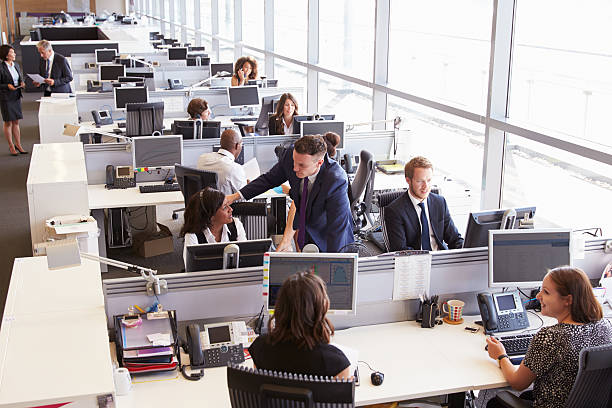 istock Manager in discussion with coworker in an open plan office 487808674