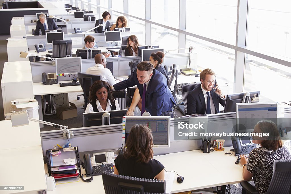 Manager in discussion with coworker in an open plan office Office Stock Photo