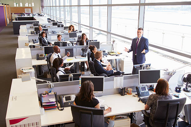 istock Young male manager addressing workers in open plan office 487808896