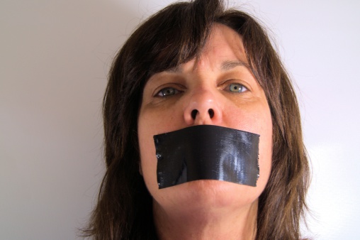 Woman with duct tape on face symbolizing censorship, shut up, mute, keep quiet.