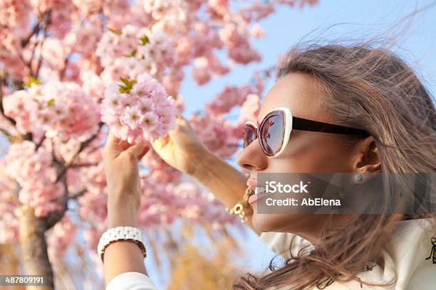 Beautiful Girl Standing Among The Branches Of Cherry Blossoms Stock Photo - Download Image Now