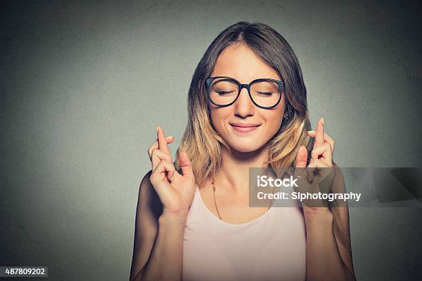 Hopeful Woman Crossing Her Fingers Eyes Closed Stock Photo - Download Image Now - Educational Exam, University, Desire