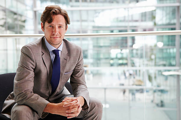 istock Corporate businessman sitting in modern interior, portrait 487809218