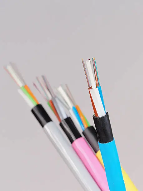 Blue fiber optic cable with stripped and  exposed fibers in front of other cables, Melbourne 2015