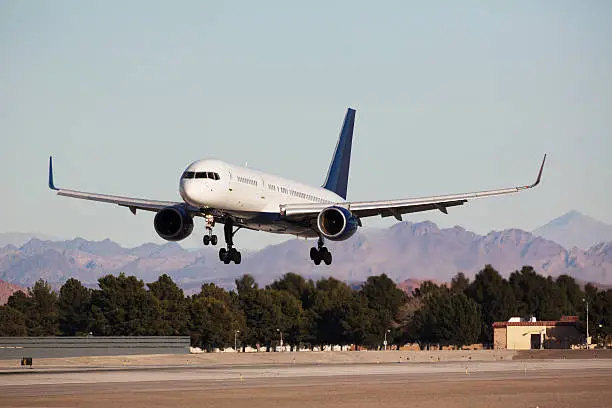 A jet on approach to the airport runway for landing.