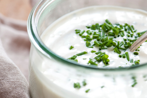 Glass jar of homemade ranch dressing with chives on linen napkin