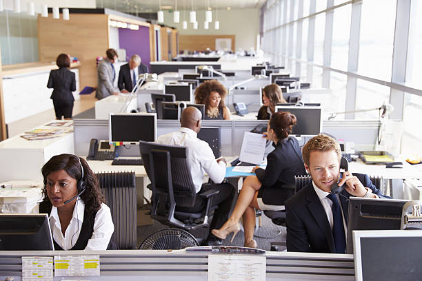 istock Colleagues busy working at desks in an open plan office 487814330