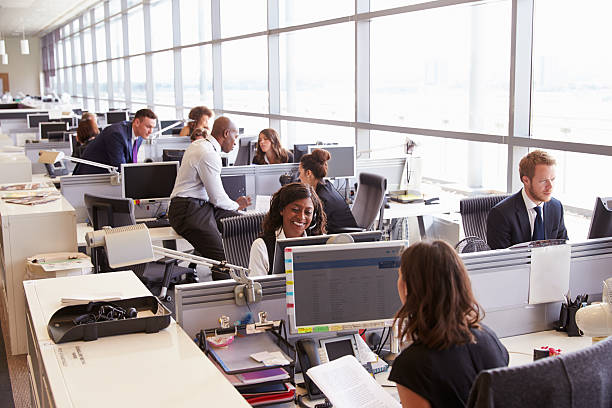 istock Coworkers at their desks in a busy, open plan office 487814400