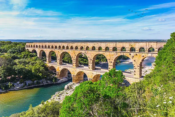 Three-tiered aqueduct Pont du Gard was built in Roman times on the river Gardon. Around the bridge is magnificent natural park. Provence, spring sunny day