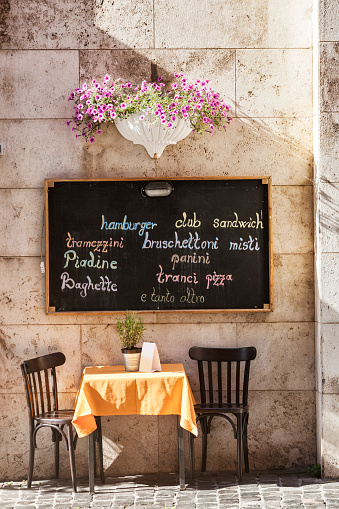 Table for two and sandwich board ion the street in downtown Rome, Italy.