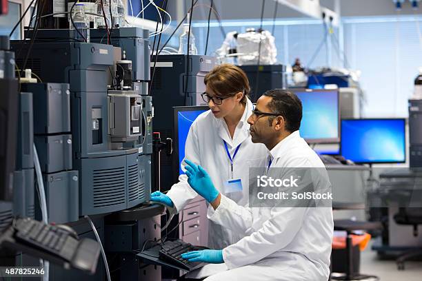 People Working With Specialist Scientific Equipment For Measuring Chemicals Stock Photo - Download Image Now