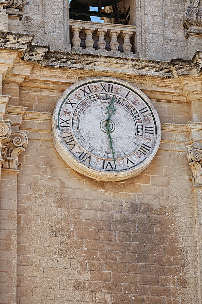 istock Old clock with Roman numerals on a bell tower 487829037