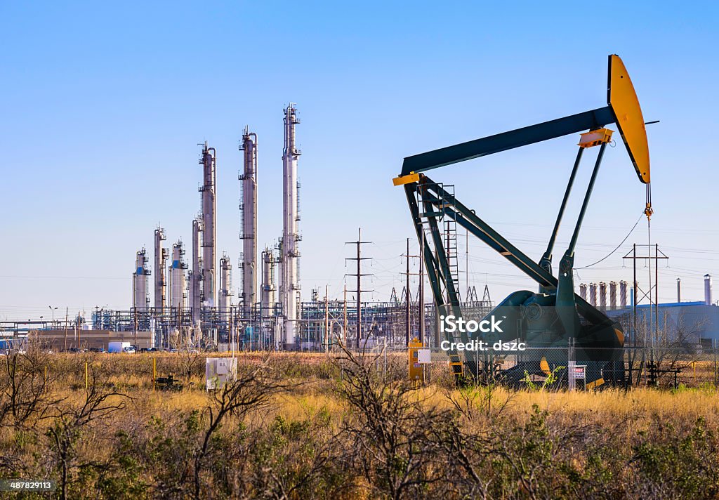 Pumpjack (oil derrick) and refinery plant in West Texas A pumpjack (oil derrick) and oil refinery in Seminole, West Texas. Crude Oil Stock Photo