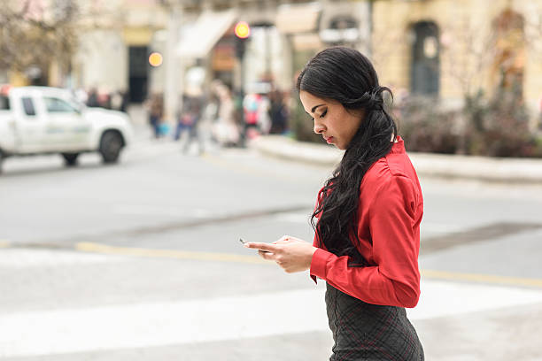istock Hispanic stewardess in urban background looking at her mobile ph 487830706