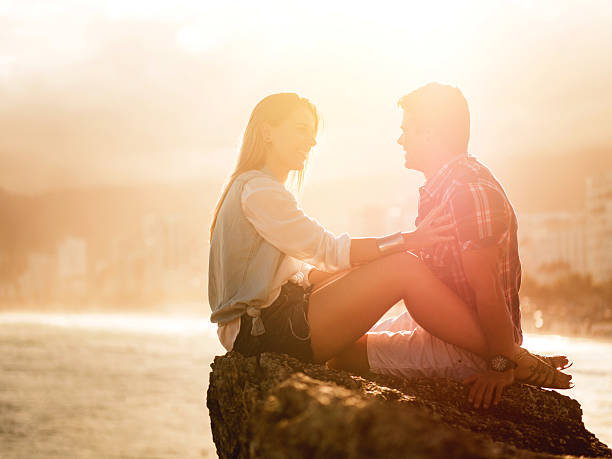 istock Romantic Latin American couple communicating on a rock at sunset. 487830800