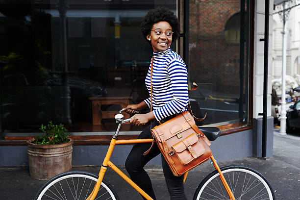 femme souriant sur la ville - faire du vélo photos et images de collection