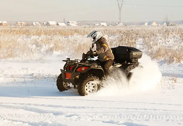 terrain vehicle in motion at winter sunny day