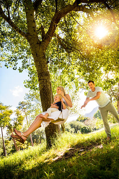 istock Mom and son on swing in park 487833941