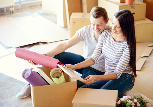 young couple in a new apartment with boxes for moving