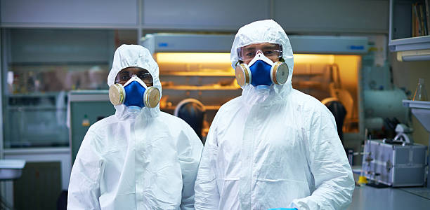 Protected scientists Two scientist wearing protective suits, glasses and mask in lab chemical worker stock pictures, royalty-free photos & images
