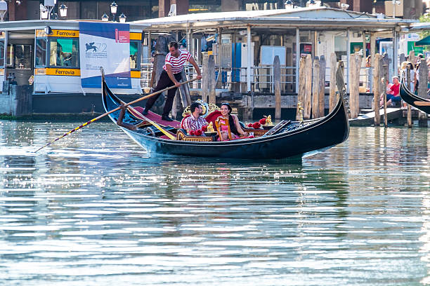 Couple enjoy a gondola ride along the Grand Canal Venice, Italy - September 6, 2015: Couple enjoy a quiet gondola ride along the Grand Canal, Venice, Italy.  venice italy grand canal honeymoon gondola stock pictures, royalty-free photos & images