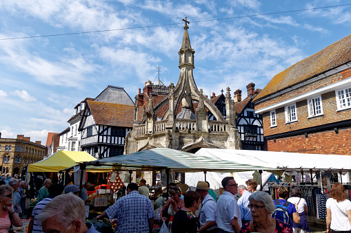 Salisbury, Wiltshire, UK- August 27, 2013:Shoppers at an outdoor market in front of the 15th Century Poultry Cross in Butcher Row, Salisbury, Wiltshire, United Kingdom, 27th August 2013.