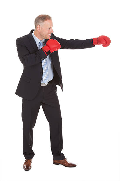 istock Businessman In Boxing Gloves Punching Over White Background 487845942