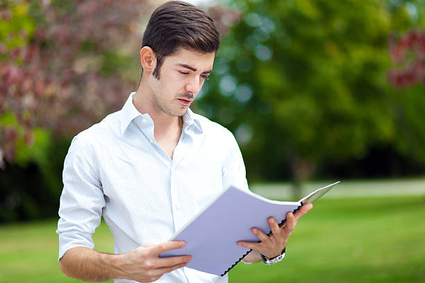 istock Male student reading outdoor 487852615