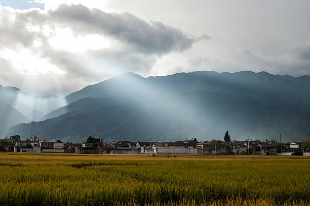 istock Rural scene with shafts of sunlight piercing the white clouds. 487853469