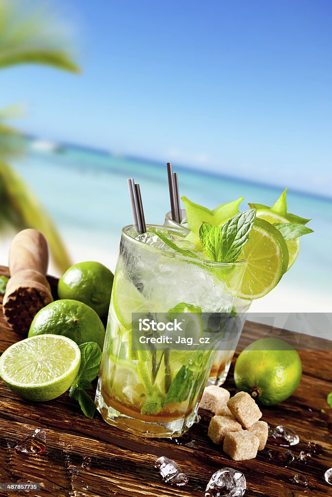 Fresh mojito cocktail on wood Mojito drink on wood with blur beach background Alcohol - Drink Stock Photo