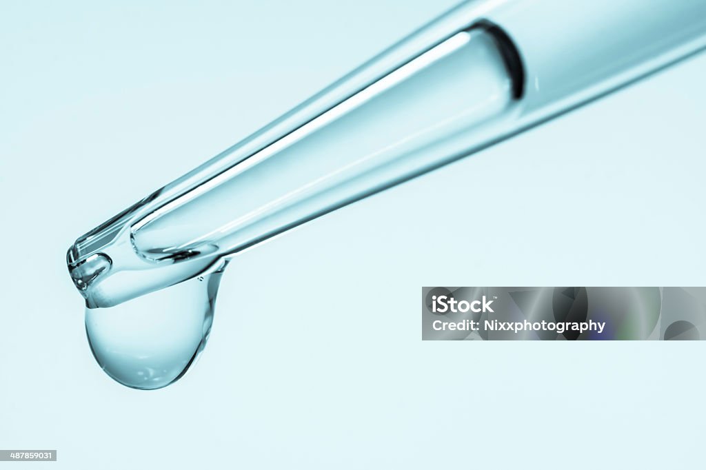 Laboratory equipment Laboratory pipette with drop of chemical liquid  over glass test tubes Acid Stock Photo